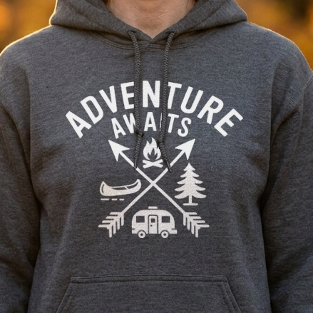 Close-up of a dark gray camping hoodie with a white Adventure Awaits design of crossed arrows, campfire, canoe and camper