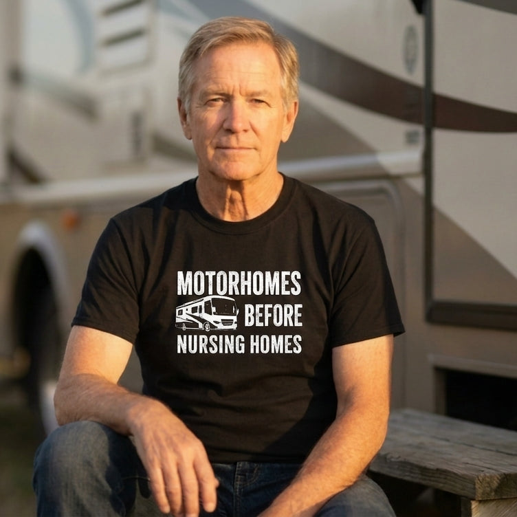 Man in a black Motorhomes Before Nursing Homes t-shirt sitting in front of an RV.