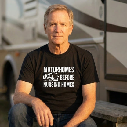 Man in a black Motorhomes Before Nursing Homes t-shirt sitting in front of an RV.