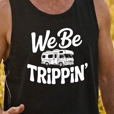 A man standing in a sunlit grassy field wearing a black tank top with a white graphic that reads 'We Be Trippin'' and a small camper illustration.
