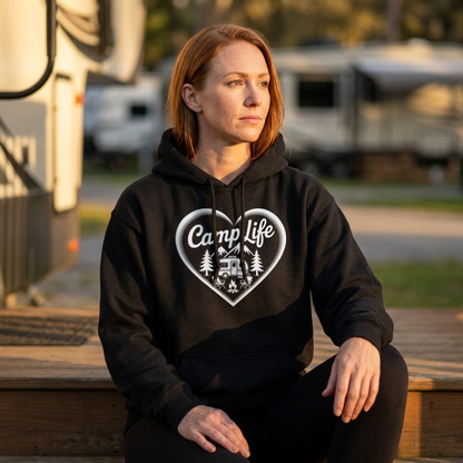 Woman in a black Camp Life heart hoodie sitting on wooden steps in front of RVs