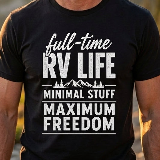 A smiling man wearing a black graphic t-shirt with white text that reads 'full-time RV LIFE MINIMAL STUFF MAXIMUM FREEDOM' stands outdoors on a mountain path during golden hour.