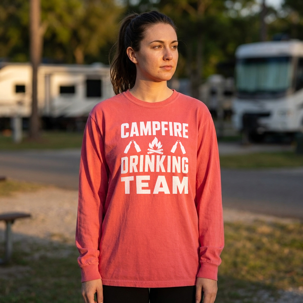 Woman in a coral Campfire Drinking Team long sleeve shirt standing in an RV campground