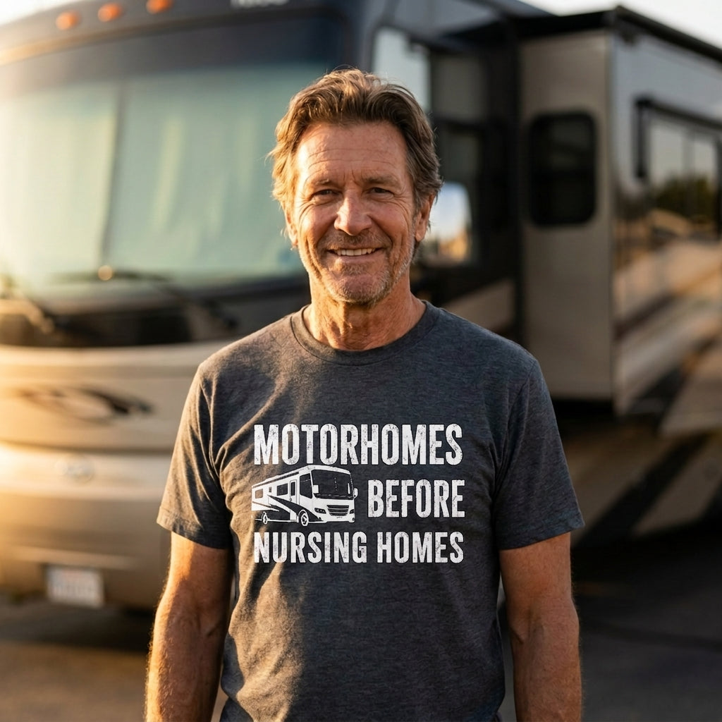 Smiling man in a dark gray Motorhomes Before Nursing Homes t-shirt in front of a large motorhome.